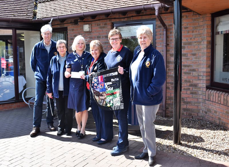 President of Winterton and District Lions Club Pauline Hollingworth (third from right) and Club member Jean Wain (second right) are pictured with other Club members presenting the cheque for £1,000 and the fidget muff to Senior Nurse Inpatient Unit Karen Andrew (third left) of Lindsey Lodge Hospice.