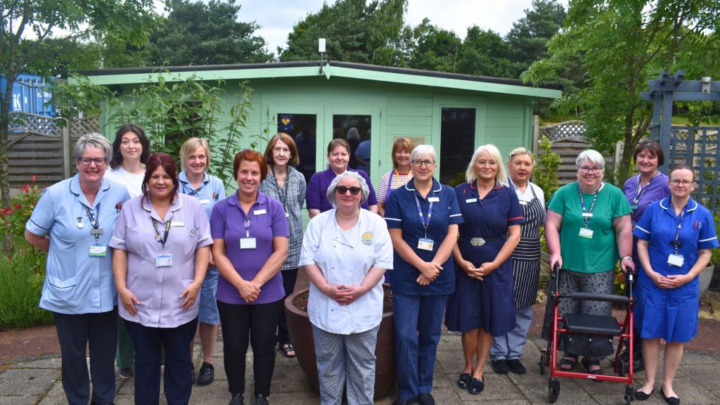 Lindsey Lodge Hospice and Healthcare Clinical Team pose for a group photo in the gardens. Image features nurses, healthcare assistants, housekeeping and catering assistants.